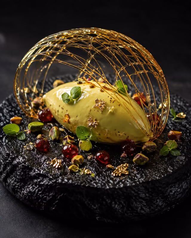 Pistachio semifreddo with spun sugar dome and sour cherries